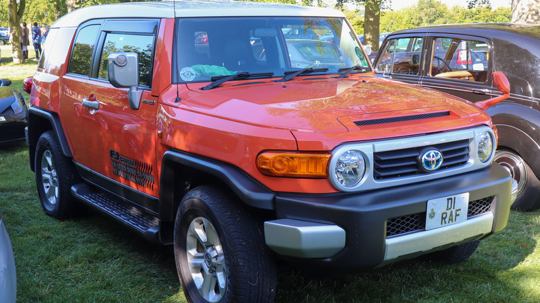 Orange 2014 Toyota FJ Cruiser parked on grass