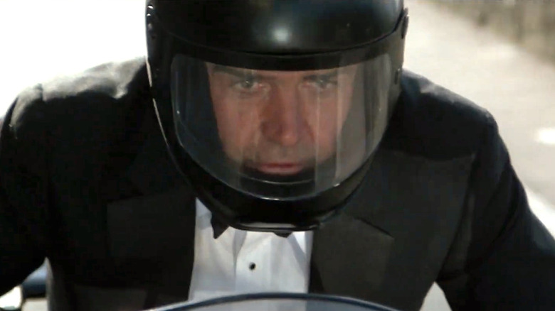 James Bond wearing helmet and riding a motorcycle