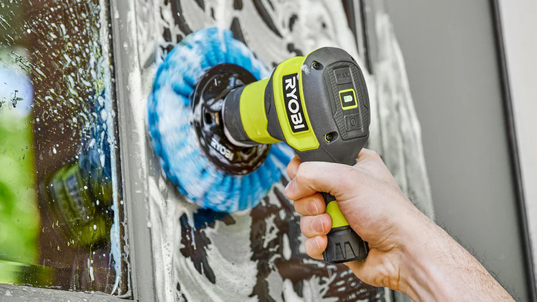 a person cleaning windows with a Ryobi USB lithium power scrubber
