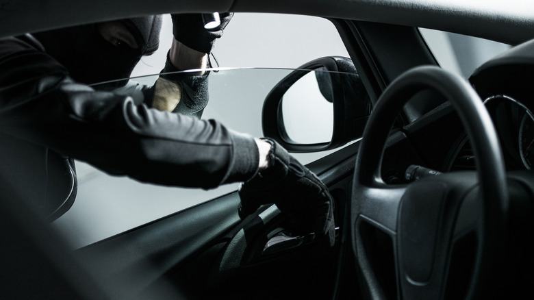 Thief sticking hand in car window
