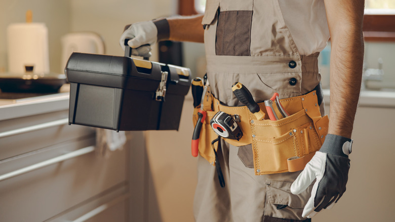 handyman with a tool belt and toolbox
