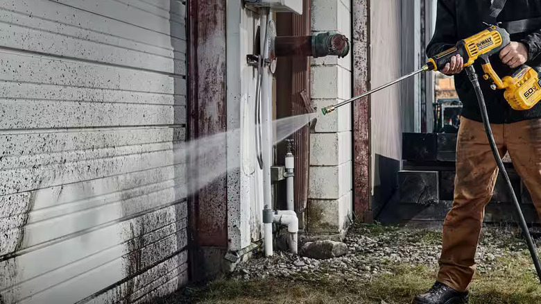 Washing down a garage door with the DeWalt power cleaner