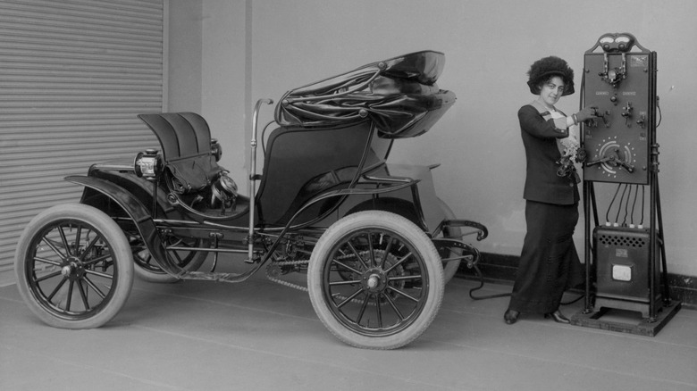A woman using an electric vehicle charger.