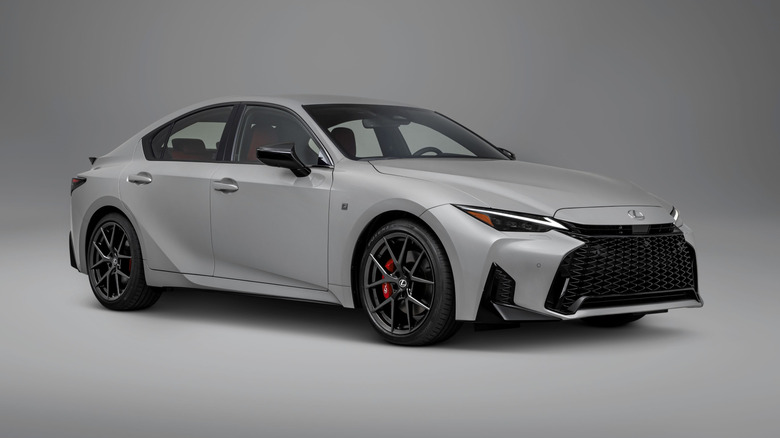 A gray 2026 Lexus IS parked in front of a gray background.
