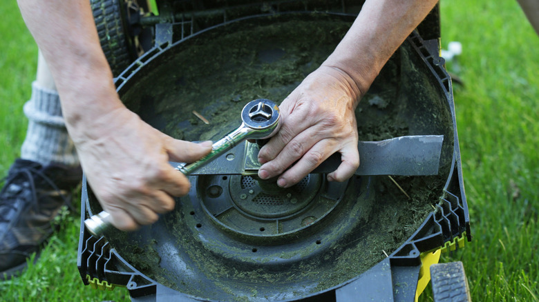 Person removing mower blade