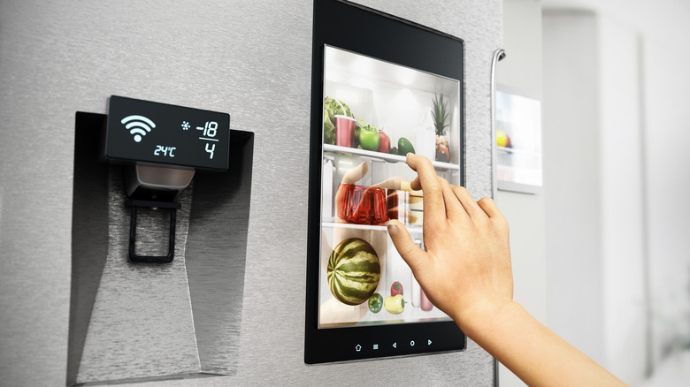 hand using display on smart fridge