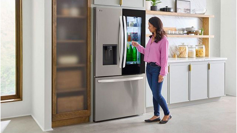 Person using LG refrigerator in kitchen