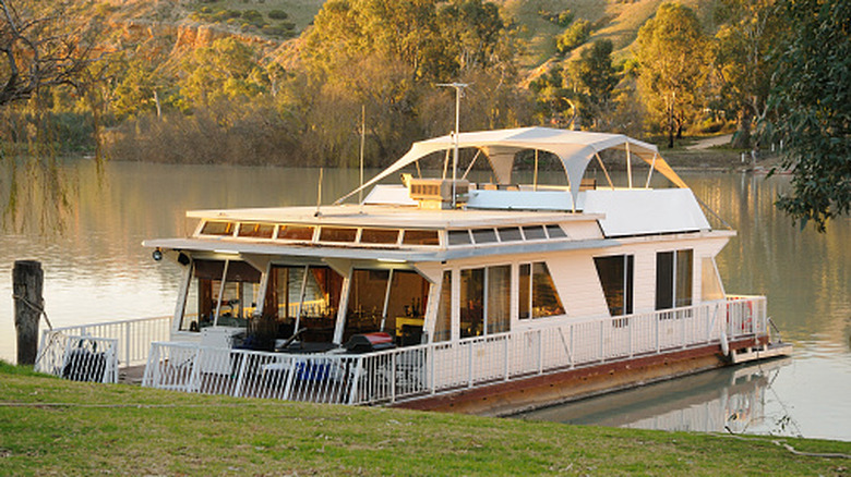 a houseboat moored on the river at sunset