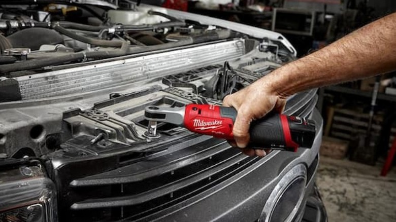 Perosn using M12 Fuel 12V Brushless Cordless High Speed ¼-inch Ratchet on car