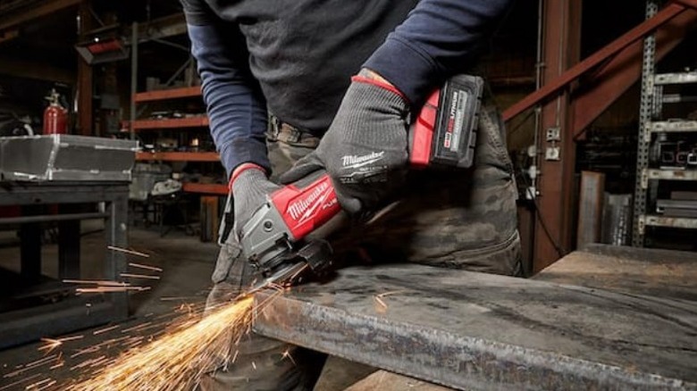 Person grinding metal with M18 Fuel 18V Brushless Cordless 4 ½-inch to 5-inch Grinder with Paddle Switch