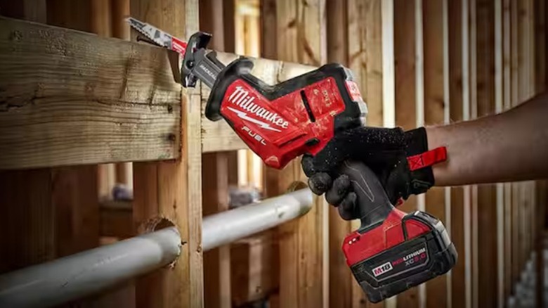 Person using M18 Fuel 18V Brushless Cordless Hackzall Reciprocating Saw to cut beam