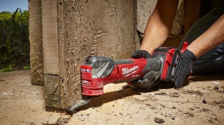 Person using M18 Fuel Brushless Cordless Oscillating Multi-Tool on trim