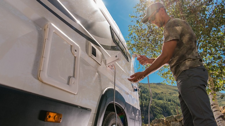 Man using hose from van