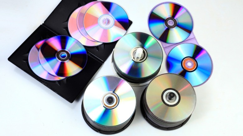 Several CDs spread out in jewel cases, holders, and plastic snap cases