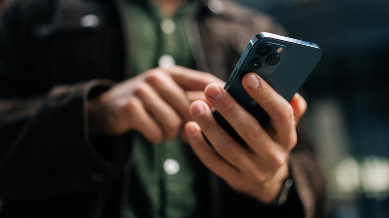 close-up of a man using a smartphone on a city street