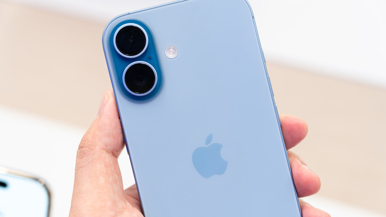 close-up of a hand holding a mint blue iPhone 17