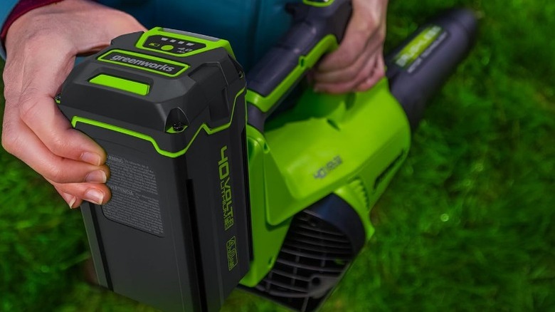 Person attaching battery to Greenworks blower