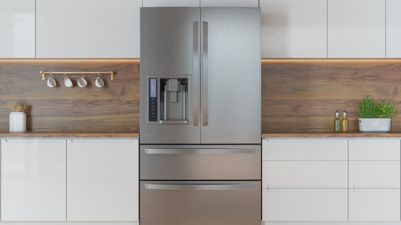 A refrigerator in the center of a kitchen.