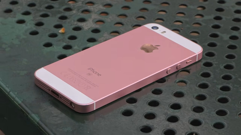 An iPhone SE lying facedown on a table outside