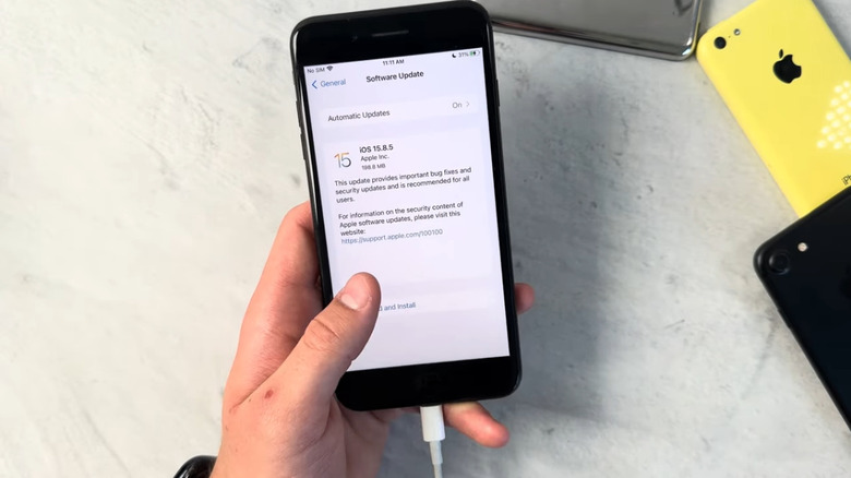 iPhone 7 Plus held in hands, showing update screen.