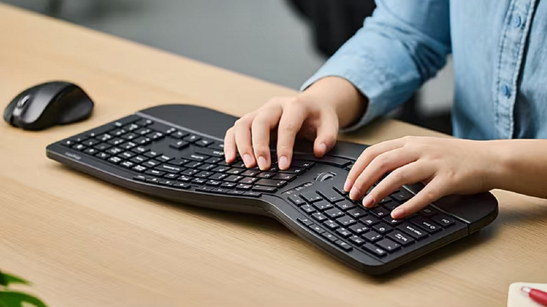 Closeup of a person using a Staples Tech keyboard and mouse on a desk