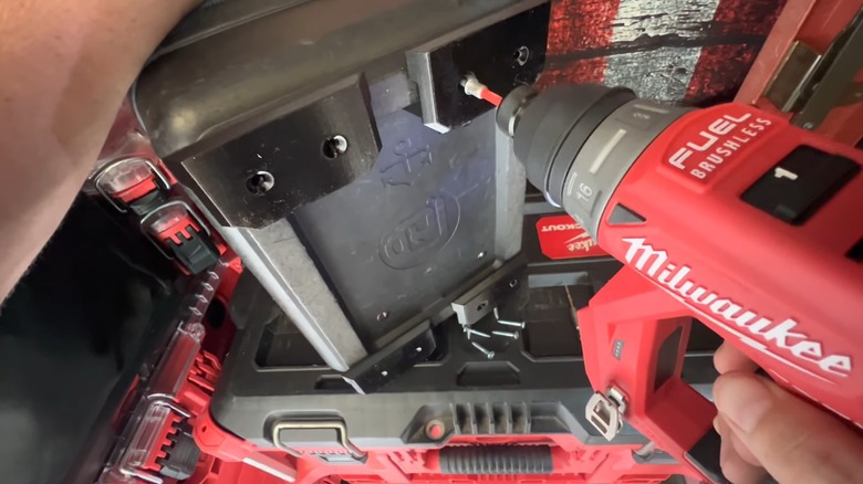 Drilling screws into a Veto Pro Pac base to secure Packout mounting feet