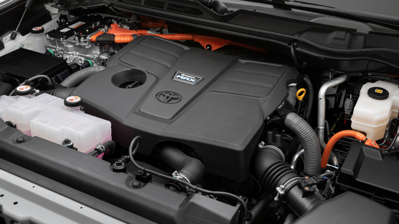 The engine bay of a red 2022 (3rd gen) Toyota Tundra pickup truck showing us the engine cover on the V35A-FTS six-cylinder engine.