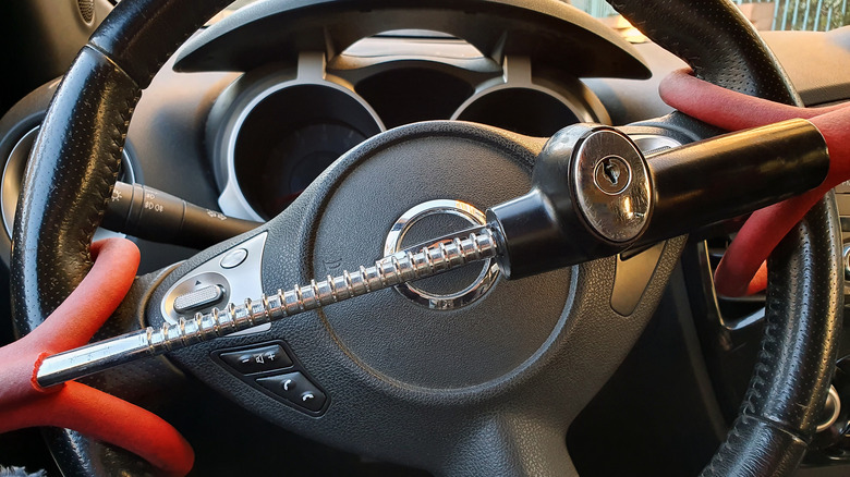 A steering wheel lock installed on a black steering wheel