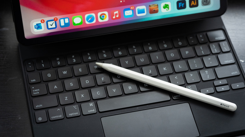 Apple Pencil resting on iPad with keyboard