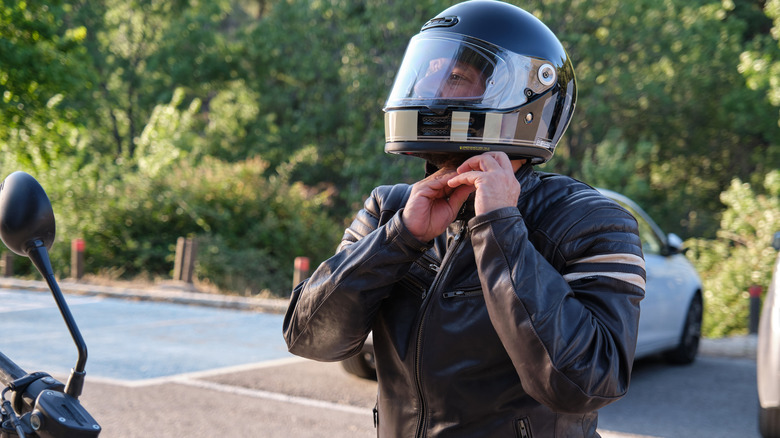 Person putting on helmet before riding motorcycle