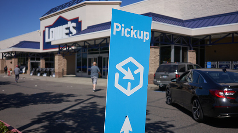A blue "Pickup" sign outside a Lowe's store, signaling the pickup area.