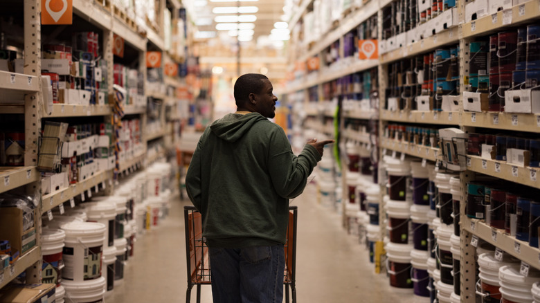 A person walks down a home improvement store aisle.