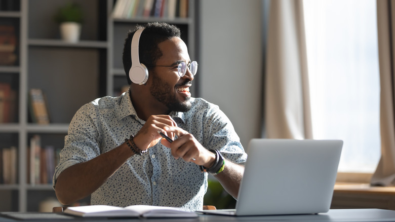 Man sitting at computer wearing wireless headphones