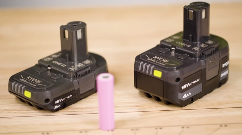 Two Ryobi batteries on a wood table.