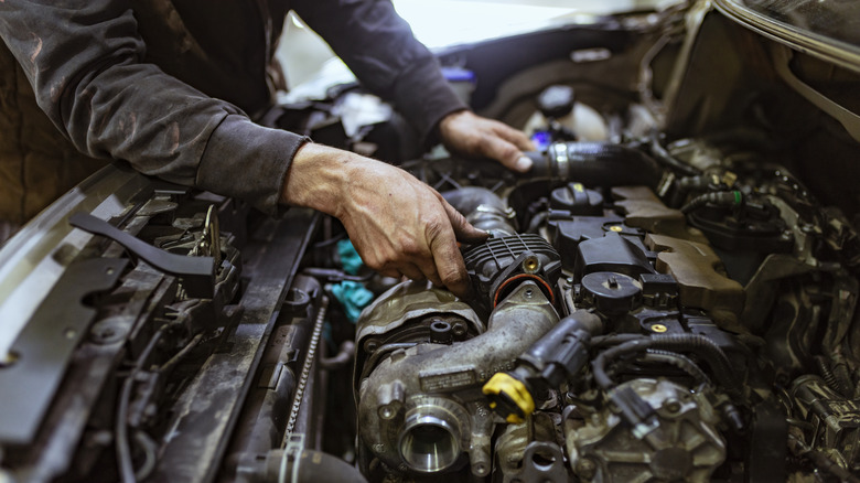 Mechanic working on car engine