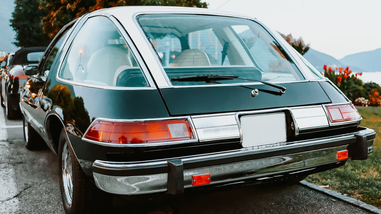 Super close-up rear 3/4 view of a dark green AMC Pacer photographed in a lakeside down