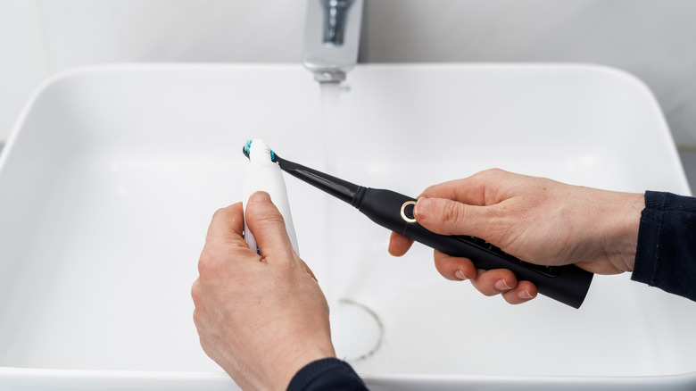 A Person Using AquaSonic Black Series Toothbrush & Travel Case With 8 DuPont Brush Heads