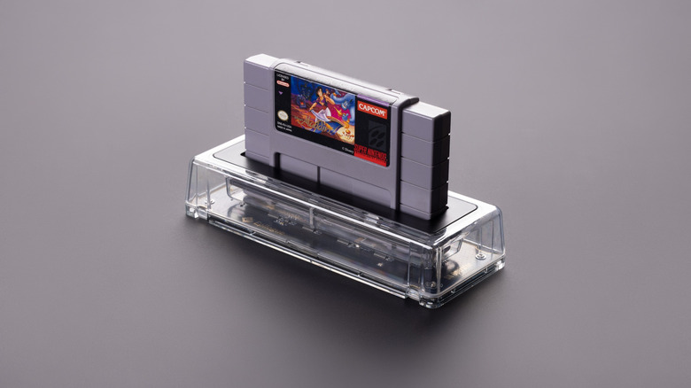 A Super Nintendo cartridge seated in the transparent Epilogue SN Operator dock