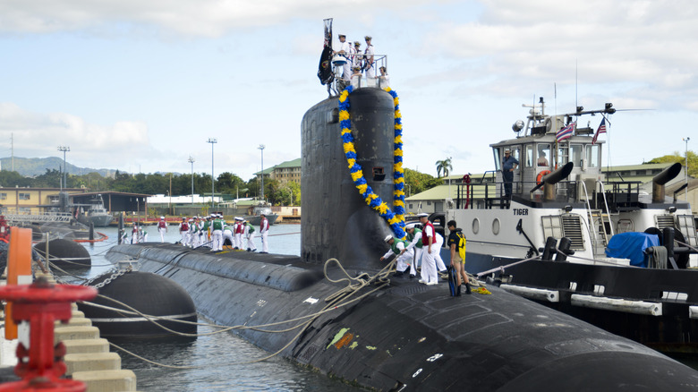 Naval officers standing atop the Virginia-class attack submarine USS Hawaii.