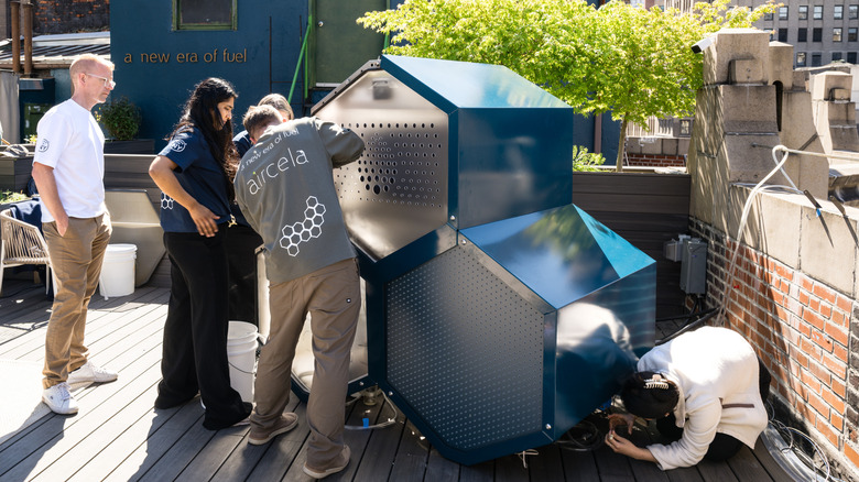A group of people working on an Aircela machine