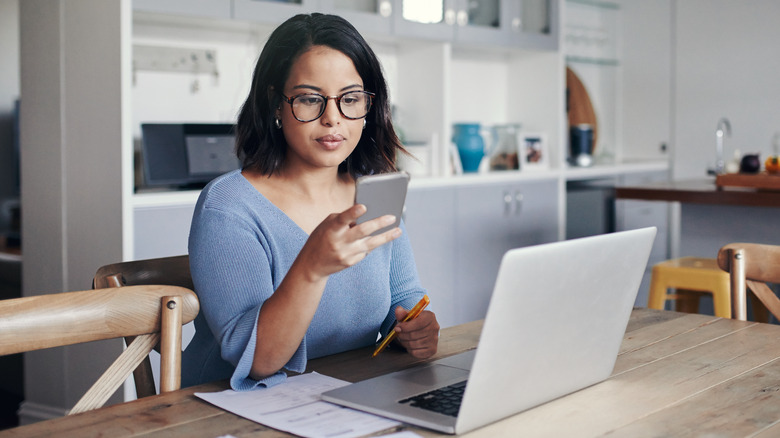 woman distracted by phone while working