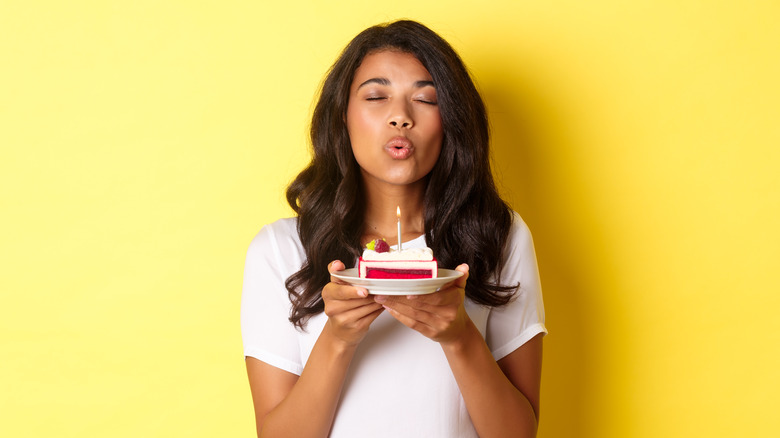 Woman blowing out candle