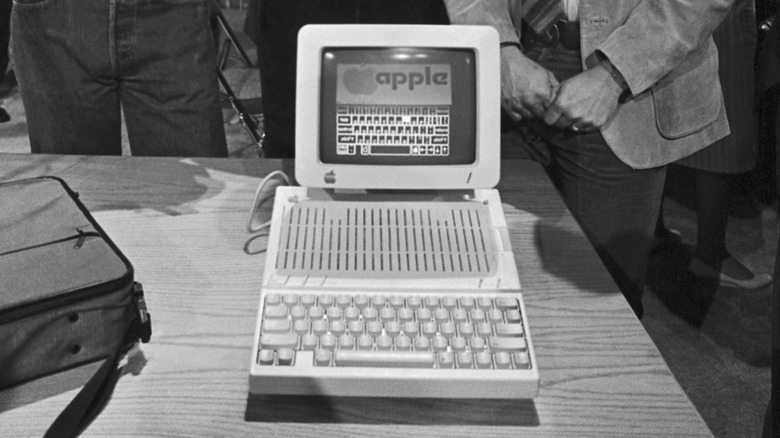 Black-and-white photo of an early Apple computer displayed on a table at an event
