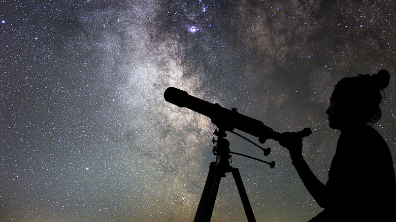 Person with telescope at night