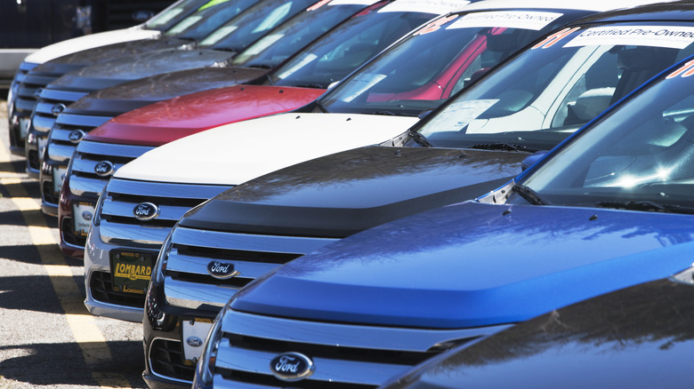 A row of Ford vehicles outside at a dealership in various colors