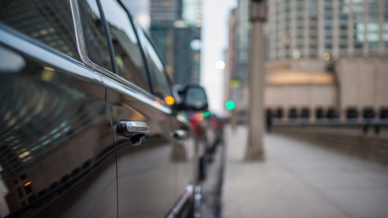 Close up of the passenger door of a black vehicle.