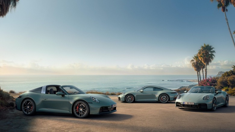 A trio of Porsche 911 models parked by the beach