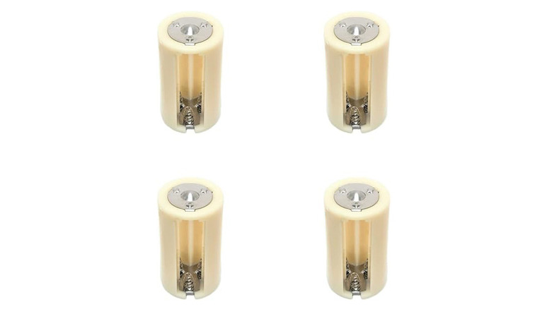 Four AA to D battery adapters on a plain white background