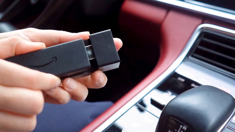 close of hands holding carlinkit device in a car