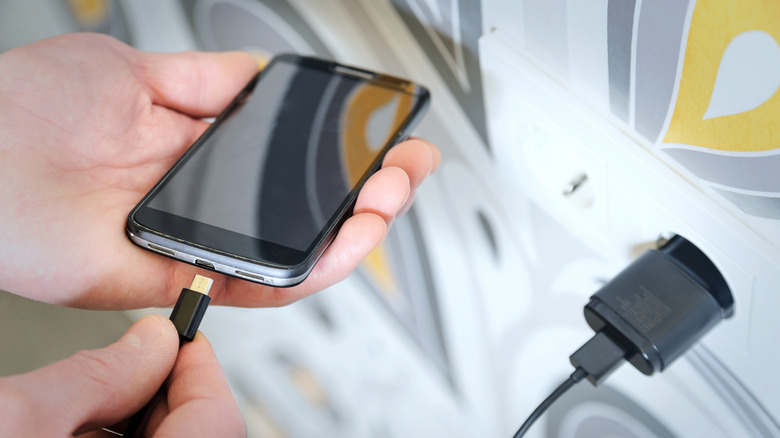 Person charging a smartphone.